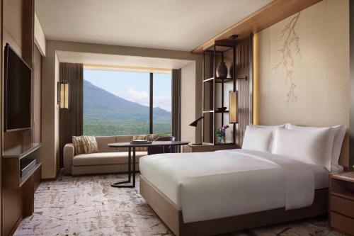 a hotel room with a large bed and a couch at Higashiyama Niseko Village, a Ritz-Carlton Reserve in Niseko