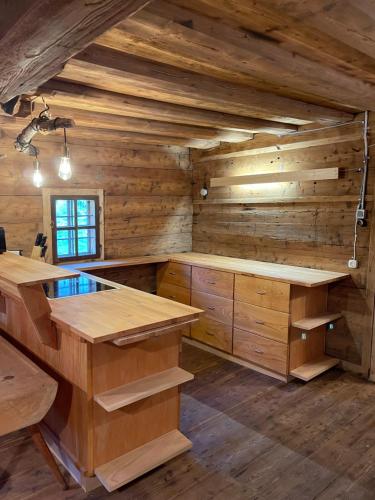a log cabin kitchen with wooden walls and wooden counters at 200-Jahre altes Koschuta Bauernhaus 