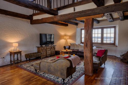 a large living room with a couch and a tv at Wohnen auf der Ritterburg in Haßmersheim