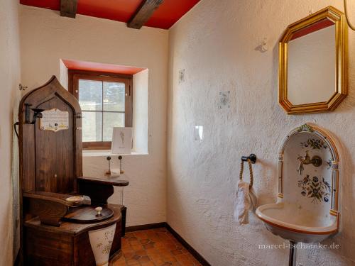 La salle de bains est pourvue d'un lavabo et d'un miroir. dans l'établissement Wohnen auf der Ritterburg, à Haßmersheim