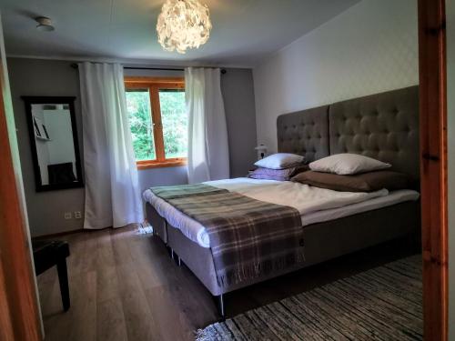 a bedroom with a large bed and a chandelier at Jojos Lodge in Bräcke