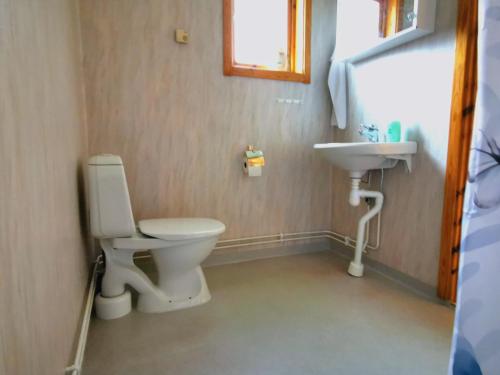 a bathroom with a toilet and a sink at Jojos Lodge in Bräcke