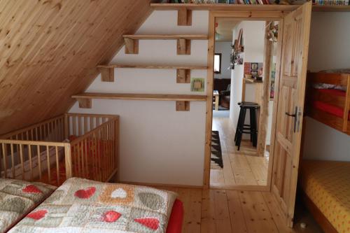 a room with a staircase and a bed in a room at Chalupa Rozcestí, z Gruntu dobré přespání in Dolní Moravice