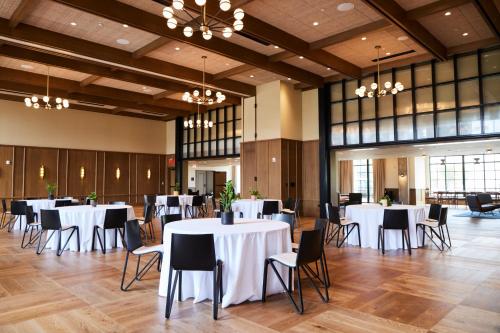a banquet hall with white tables and chairs at The Junto Hotel in Columbus