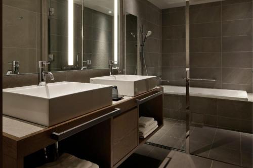 a bathroom with two sinks and a tub and a mirror at HIDEOUT in Kyoto