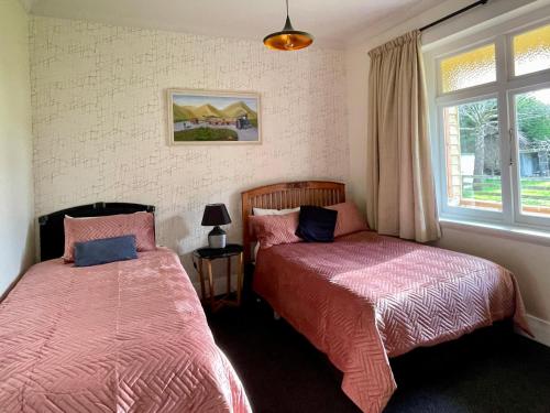 1 dormitorio con 2 camas y ventana en Big Fully Equipped 3BRM Quiet Farm House Near Beach & 12 min to Town en Riverton