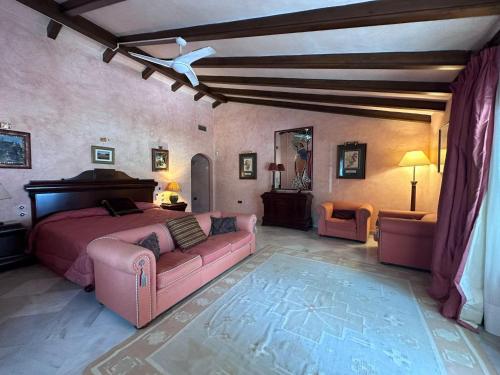 um quarto com uma cama rosa e um sofá em Casa Cabopino em Marbella