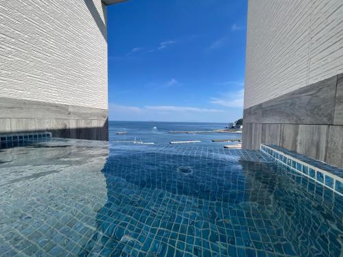 a swimming pool with a view of the ocean at Grandview Atami Private Hot Spring Condominium Hotel in Atami