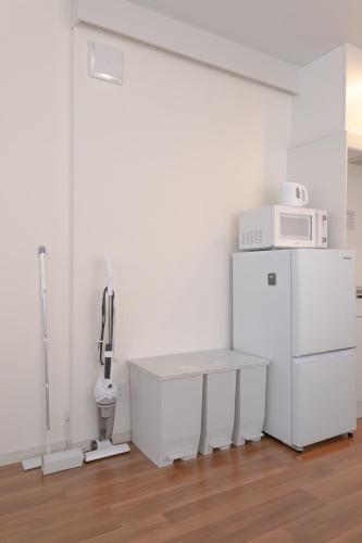 a kitchen with a white refrigerator and a microwave at RIVER VILLAS HIROSHIMA in Hiroshima
