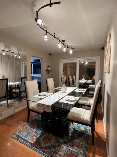 a dining room and living room with a table and chairs at Luxe 3BR, 2BA + Hot Tub in Elmhurst