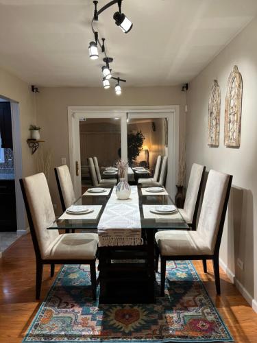 a dining room with a long table and chairs at Luxe 3BR, 2BA + Hot Tub in Elmhurst