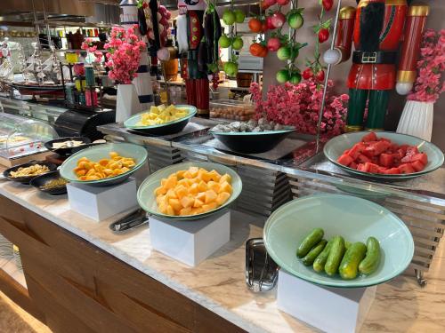 a buffet with fruits and vegetables in bowls on a counter at Grand Barony Qingdao Airport Hotel in Qingdao