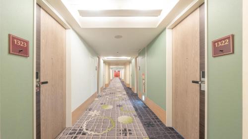 a long hallway with tile floors and green walls at New Otani Inn Sapporo in Sapporo