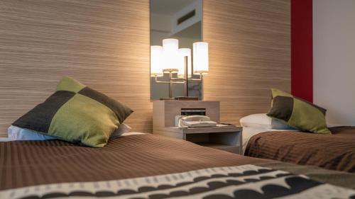 a hotel room with two beds and a clock at New Otani Inn Sapporo in Sapporo