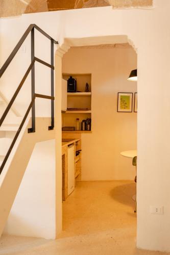 a staircase in a room with a white wall and a table at le CASINE di MARUGGIO 10 in Maruggio
