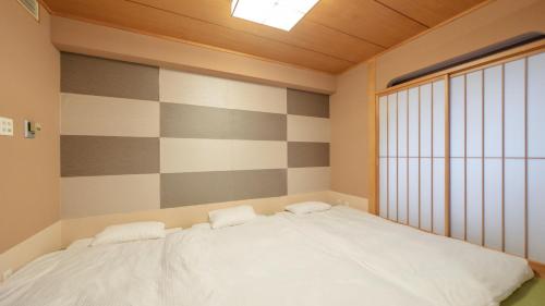 a bedroom with a bed and a large window at New Otani Inn Sapporo in Sapporo