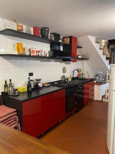 cocina con fogones negros y rojos horno superior en Wedding and Family House, en Malcesine