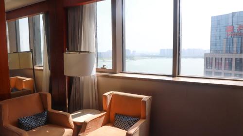 um quarto de hotel com duas cadeiras e uma janela em Four Points by Sheraton Suzhou em Suzhou