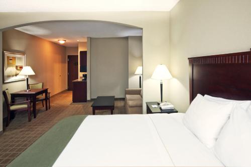 a hotel room with a bed and a desk at Holiday Inn Express Hotel & Suites Shawnee I-40 by IHG in Shawnee