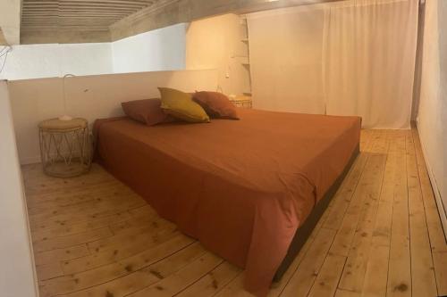 uma cama grande num quarto com piso em madeira em Appart avec parking, 150m du Vieux Port, 50 m2 em La Ciotat