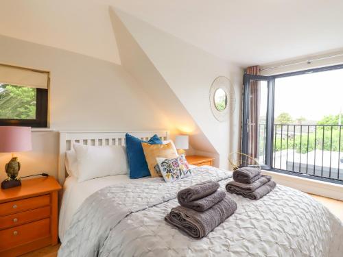 a bedroom with a bed with towels on it at Kite View Cottage in High Wycombe