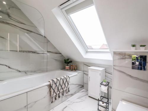 a bathroom with a bath tub and a skylight at Kite View Cottage in High Wycombe