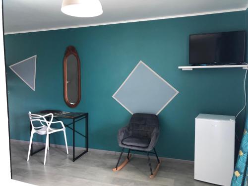 a room with a table and a chair and a television at Hôtel Le Soleil Couchant in Saint-Pierre