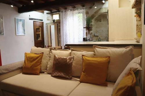 - un canapé avec plusieurs oreillers dans l'établissement Entre Uzès et le Pont-du-Gard le Logis d'Autrefois, à Castillon-du-Gard