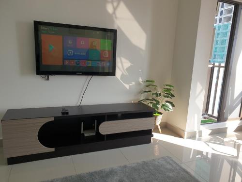uma sala de estar com uma televisão de ecrã plano na parede em Bali Residence Melaka by Naufal em Malaca