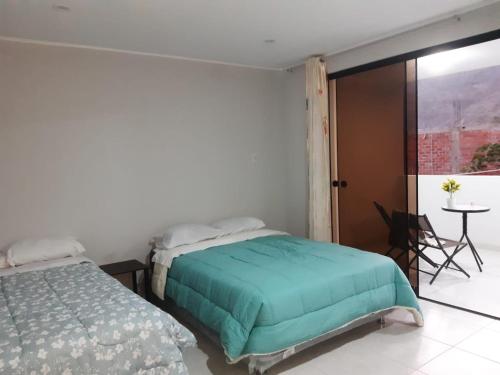 um quarto com uma cama, uma mesa e uma janela em El Valle Lunahuaná em Lunahuaná