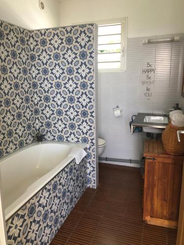 a bathroom with a bath tub and a sink at Hôtel Le Soleil Couchant in Saint-Pierre
