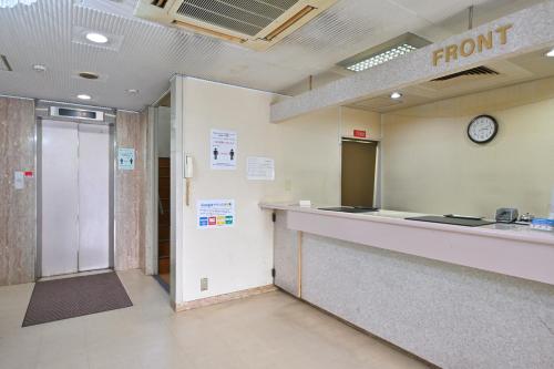 a waiting room with a front desk and a clock at Wakayama Daiichi Fuji Hotel in Wakayama