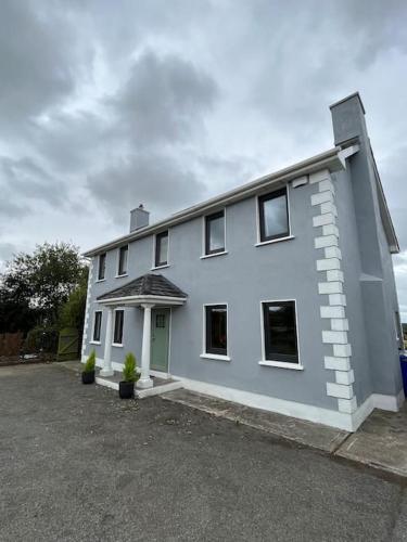 a white house with a lot of windows at An Teach Bábóige - The Doll house - Kildare in Kildare