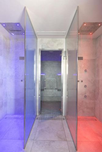 a bathroom with a walk in shower with a glass door at Hotel Ambrosiana in Misano Adriatico