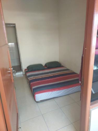 a small bedroom with a bed in a room at Nusantara kost syariah bulanan harian in Kalasan