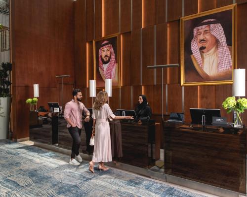 a group of people standing in a lobby at Jeddah Marriott Hotel Madinah Road in Jeddah