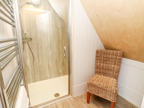 a bathroom with a shower and a chair at Lodge 6 in Wareham