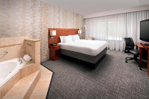 Pokój hotelowy z łóżkiem, wanną i umywalką w obiekcie Courtyard by Marriott Lufkin w mieście Lufkin
