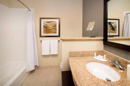 a bathroom with a sink and a bath tub at Courtyard by Marriott Lufkin in Lufkin