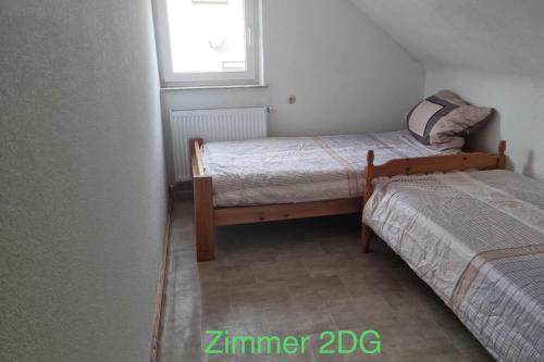 a small bedroom with two beds and a window at Semi-Detached House on 2 Floors in Giengen an der Brenz