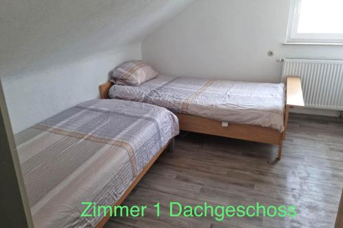 a small room with two beds and a window at Semi-Detached House on 2 Floors in Giengen an der Brenz