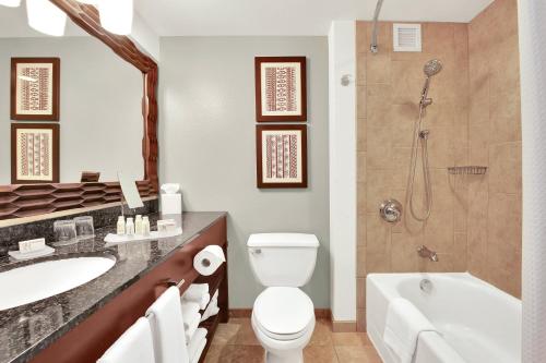 a bathroom with a toilet and a sink and a shower at Courtyard by Marriott King Kamehameha's Kona Beach Hotel in Kailua-Kona