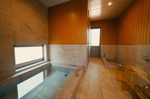 a large bathroom with a swimming pool and a tub at Private Villa ietona in Fujikawaguchiko