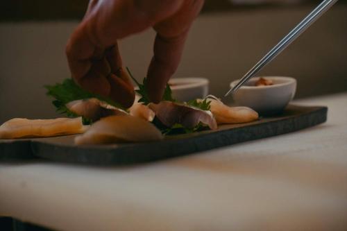 a person is preparing food on a plate with a plate at Private Villa ietona in Fujikawaguchiko