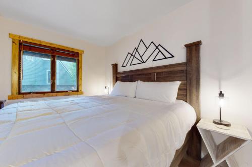 a large white bed in a bedroom with a window at The Copperado at Copper Valley in Copper Mountain
