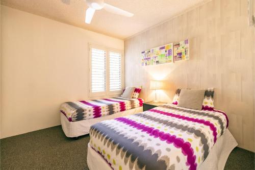 een kamer met 2 bedden en een raam bij Bay Parklands 27 2 Gowrie Ave pool tennis court spa and views in Nelson Bay