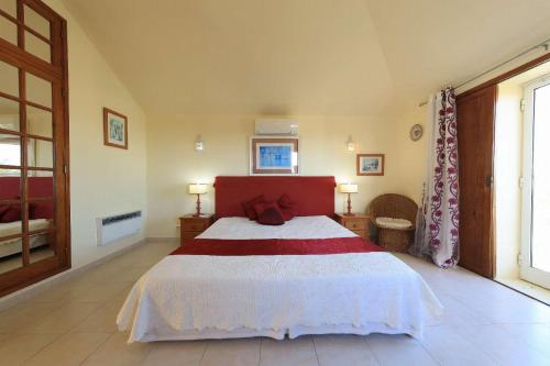1 dormitorio con 1 cama con manta roja y blanca en Villa Brejos, en Albufeira