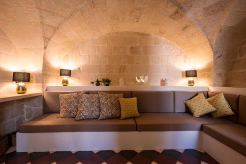 a couch in a room with a stone wall at le CASINE di MARUGGIO 19 in Maruggio