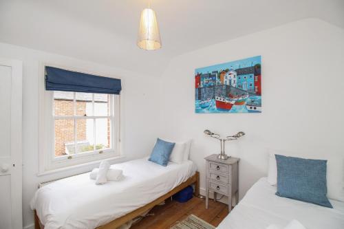une chambre avec deux lits et une fenêtre dans l'établissement Pixie Cottage, à Weymouth