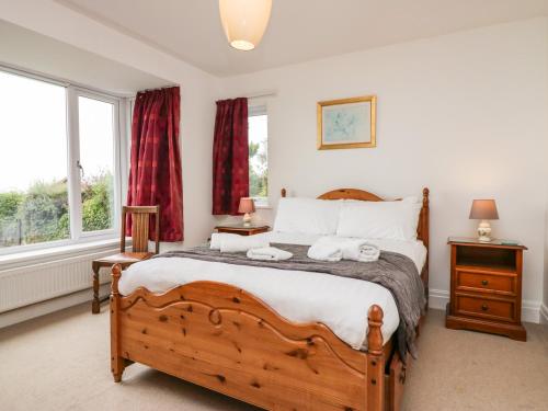 a bedroom with a large bed with two towels at Bay View Cottage in Grange Over Sands